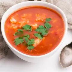 Aksamitna zupa pomidorowa na kostce, z ryżem i natką pietruszki, gotowa do podania.