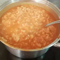 Gęsta zupa pomidorowa z ryżem w garnku, gotowa do podania. Idealna, by dowiedzieć się, jak zaprawić zupę pomidorową.