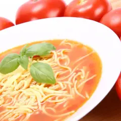 Pomidorowa z rosołu: zupa z makaronem i bazylią, obok świeże pomidory.