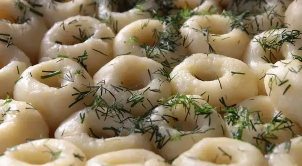 Pyszne kluski śląskie, idealne do sosu, posypane świeżym koperkiem.