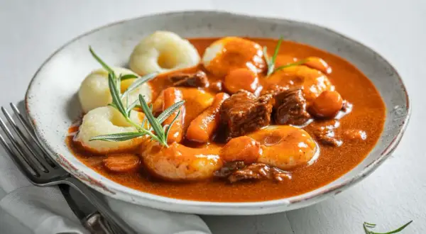 Gulasz z kluskami śląskimi i marchewką. Dowiedz się, jak zamrozić kluski śląskie surowe czy gotowane, by cieszyć się smakiem dania.