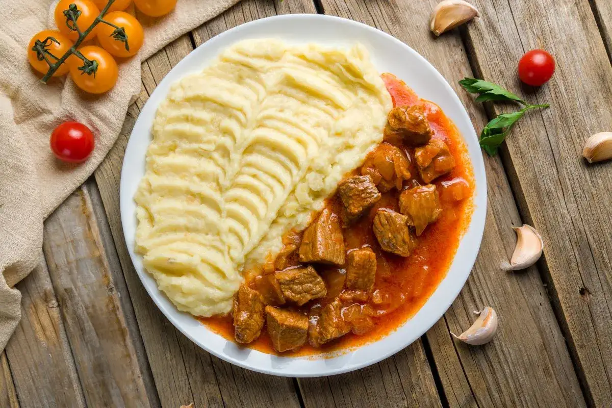 Gulasz wieprzowy z puree ziemniaczanym. Kiedy solić mięso wieprzowe na gulasz? Najlepiej przed smażeniem, by wydobyć smak.